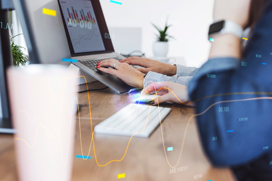 Mujeres que trabajan con un ordenador en cuya pantalla aparece una gráfica similar a Looker Studio