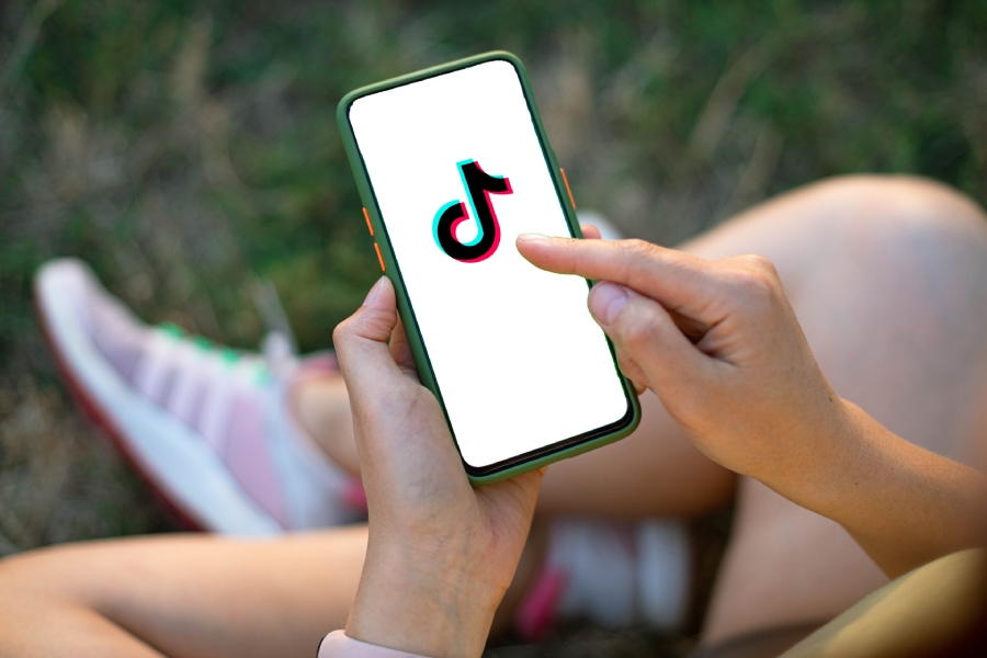 Unas manos sostienen un teléfono móvil con la app de TikTok en la pantalla 