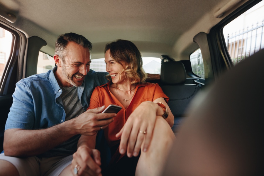 Pareja sonríe mientras mira un teléfono móvil