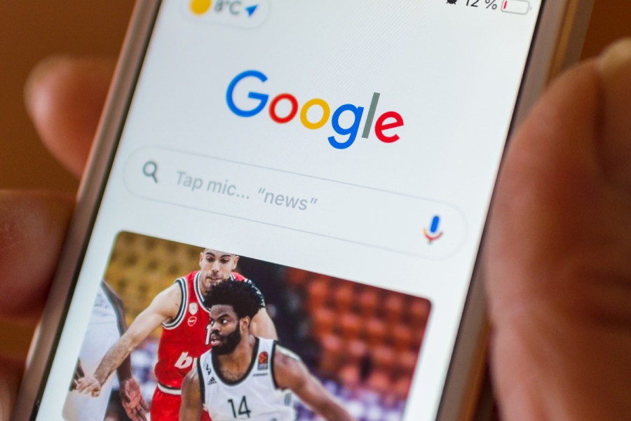 Smartphone con logo de Google en la pantalla e imagen de una noticia de baloncesto. 